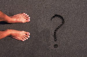 pies sobre la arena con interrogación